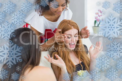 Cheerful young women surprising friend with a gift