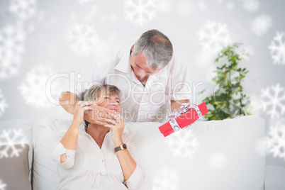 Composite image of old man hiding eyes his wife to give a gift
