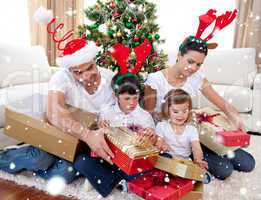 Composite image of happy family opening christmas presents at ho
