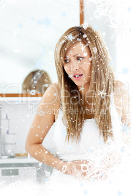 Attractive woman having a stomach ache in the bathroom