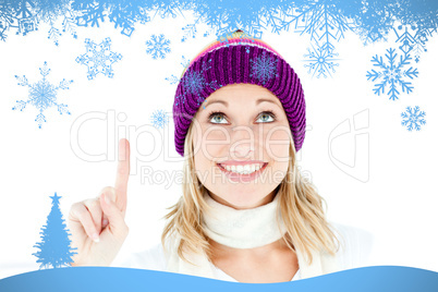 Composite image of bright woman with a colorful hat pointing upw