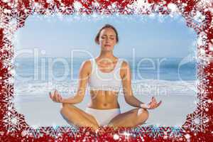 Composite image of fit woman sitting in lotus pose on the beach