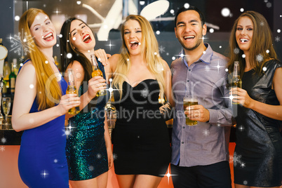 Composite image of laughing friends holding beers posing