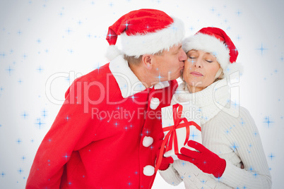 Festive couple smiling and holding gift