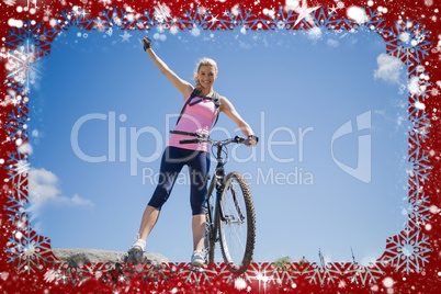 Fit pretty cyclist on a rocky terrain smiling at camera