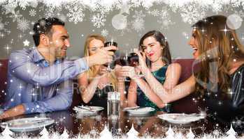 Composite image of happy friends drinking red wine in a bar