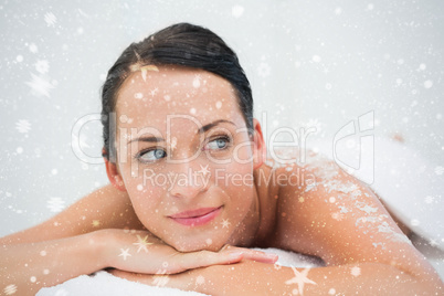 Peaceful brunette lying with salt scrub on back