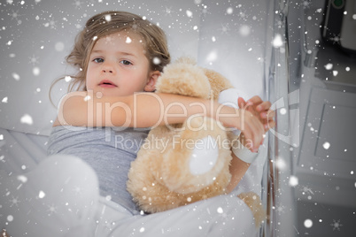 Composite image of cute girl hugging teddy bear in hospital bed