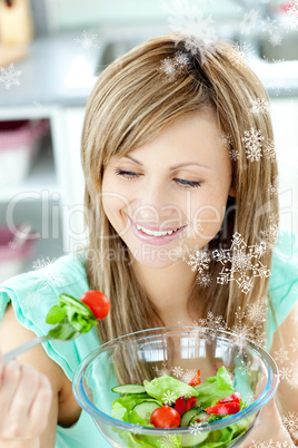 Young woman eating a salad in the kitchen