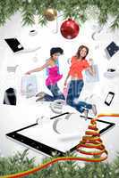 Composite image of two smiling women jumping on a tablet pc