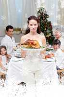 Composite image of mother showing turkey for christmas dinner