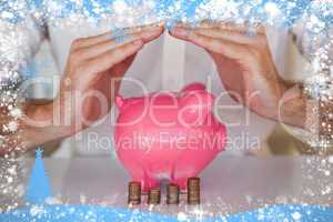 Composite image of casual businessman sheltering piggy bank and