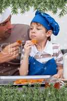 Composite image of father and son eating cookies