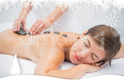 Beautiful woman receiving stone massage at spa center