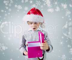 Composite image of cute festive boy opening present