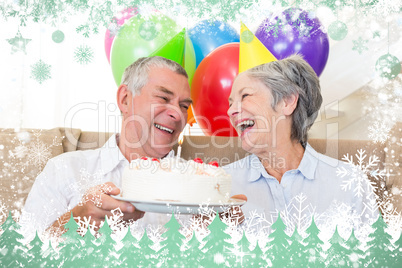 Senior couple sitting on couch celebrating a birthday