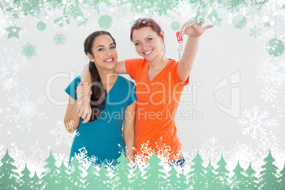 Portrait of two cheerful female friends with house keys