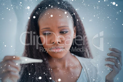 Composite image of close up of ill woman measuring her temperatu