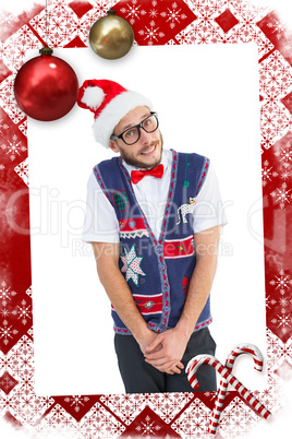 Composite image of geeky hipster in santa hat