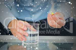 Close up of man holding glass of water and pill