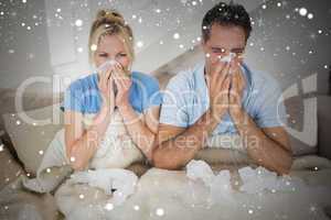 Composite image of couple suffering from cold in bed