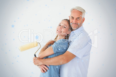 Happy couple hugging and holding paint roller