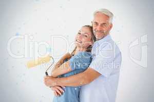 Happy couple hugging and holding paint roller