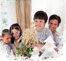 Smiling family decorating a christmas tree at home