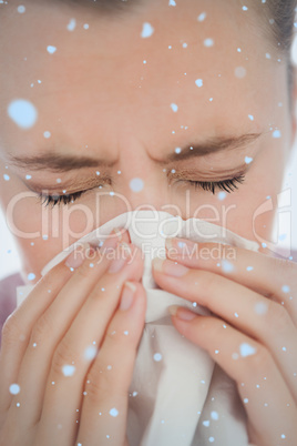 Composite image of woman blowing her nose