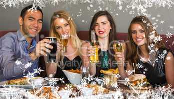 Composite image of friends having dinner together smiling at cam