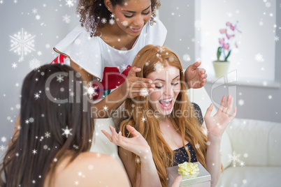 Composite image of cheerful young women surprising friend with a
