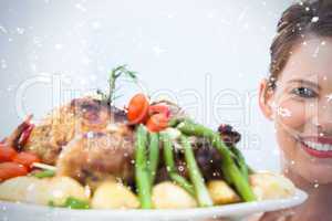 Smiling woman showing roast chicken