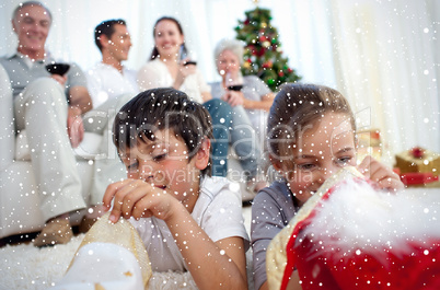 Composite image of children looking for presents in christmas bo