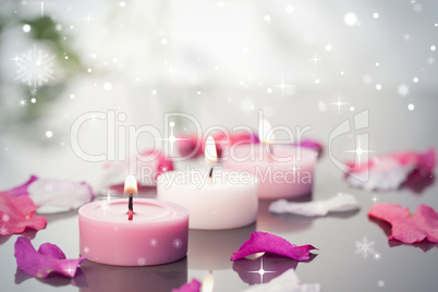 Composite image of lighted candles and petals