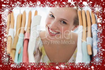 Happy female customer amid clothes rack