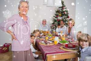 Composite image of grandmother standing beside dinner table