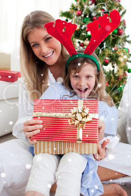 Composite image of smiling mother and her daughter opening chris