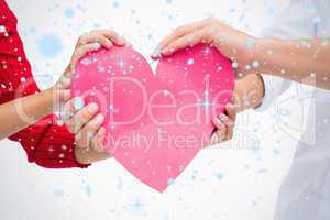 Composite image of couples hands holding pink heart