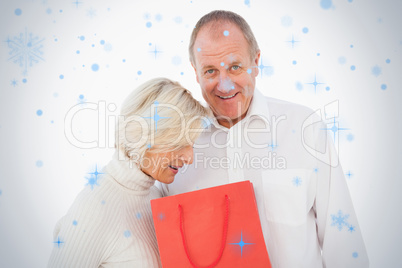 Older couple holding red gift bag