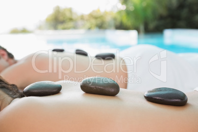 Mid section of a couple enjoying stone massage