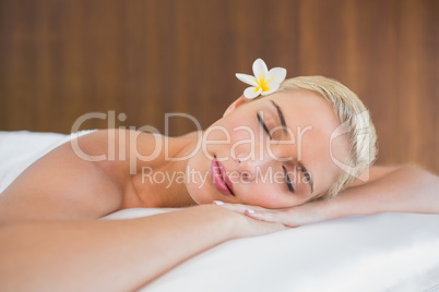 Beautiful woman lying on massage table at spa center