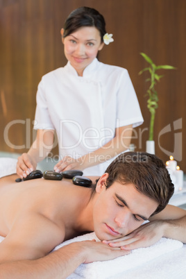 Man receiving stone massage at spa center