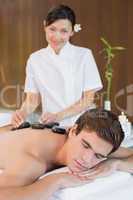 Man receiving stone massage at spa center