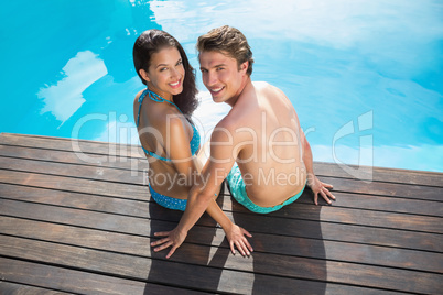 Romantic young couple by swimming pool on a sunny day