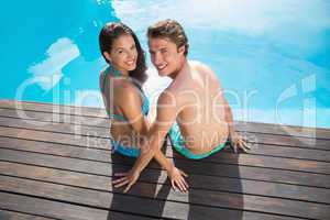 Romantic young couple by swimming pool on a sunny day