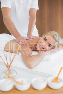 Woman receiving back massage at spa center