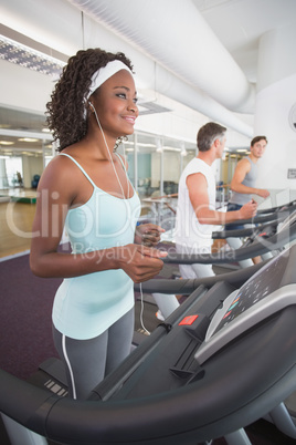 Fit woman on treadmill listening to music