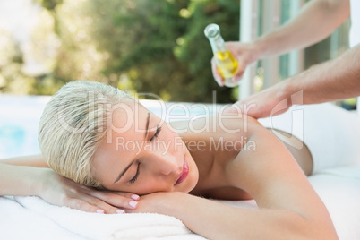 Woman receiving back massage at spa center