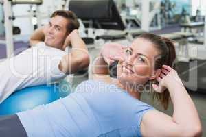 Couple doing sit ups on exercise balls