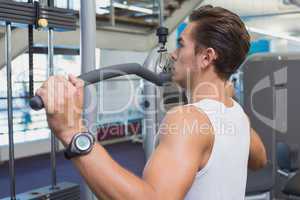 Strong man using weights machine for arms